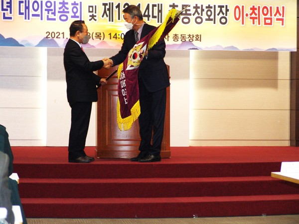 제13대 이영계동창회장(오른쪽)이 동창회기를 이홍기 신임회장(왼쪽)에게동창회기를 이양하고 있다(사진=육군사관학교동창회 제공)