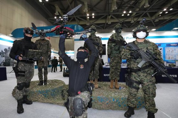 지난해 11월 18일 경기도 고양시 킨텍스에서 열린 ‘2020 대한민국 방위산업전(DX Korea 2020)’에서 육군 드론 운용 요원들과 워리어 플랫폼을 착용한 장병이 포즈를 취하고 있다.