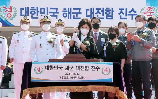 3일 경남 거제 대우조선해양 옥포조선소에서 열린 신형 호위함 ‘대전함’ 진수식에서 부석종 해군참모총장의 부인 백미자 씨가 해군 관습에 따라 손도끼로 함정에 연결된 진수줄을 절단하고 있다. (사진=해군 제공) 