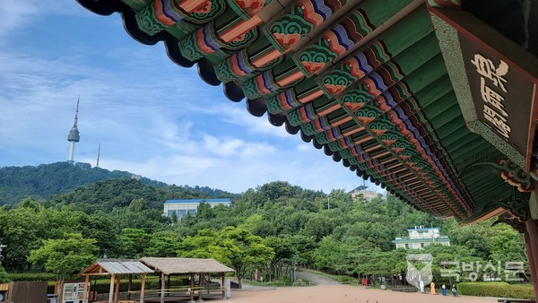 남산골 한옥 마을의 천우각에서 바라본 서울 타워. 조선후기 금위영 천우각을 새로 웅장하게 지었다. 주변 조그만한 정자나 원두막은 출입통제를 하였으나 공간이 넓은 천우각은 제한없이 올라 휴식을 취할수 있다. 