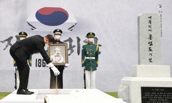 문재인 대통령이 18일 대전현충원 홍범도 장군 묘역에서 허토를 하고 있다.