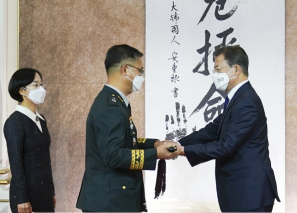 문재인 대통령이 16일 청와대 영빈관에서 열린 육‧해‧공군과 해병대 준장 진급자 76명에게 삼정검을 수여하고 있다.(사진=이하 청와대 제공)