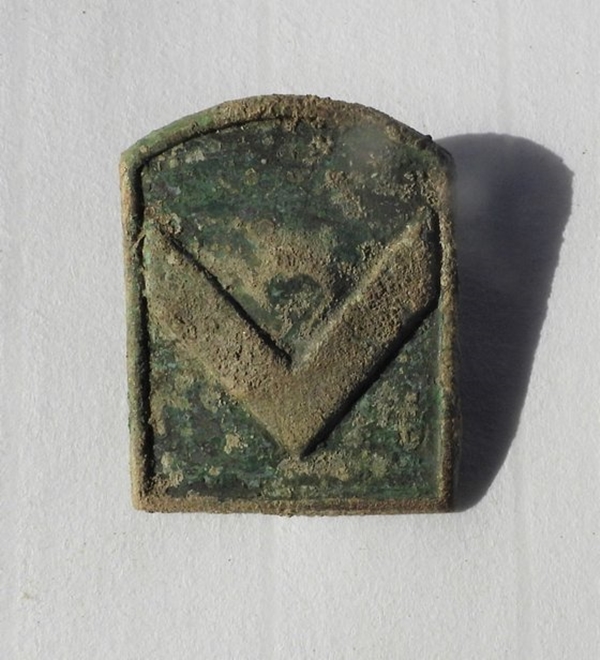 백마고지 395고지 정상에서 전투 자세를 유지하고 있는 6.25 전사 유해와 함게 발굴된 당시 일등병(현 이등병 해당) 계급장.(사진=국방부 제공)