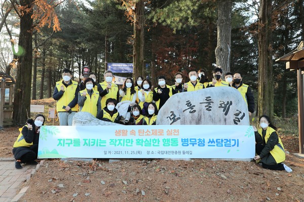 정석환 병무청장(두 번째줄 왼쪽에서 세 번째)이 25일 대전현충원을 방문하여 탄소제로 실천을 위한 쓰담걷기(플로깅) 행사를 하고 함께 참여한 직원들과 기념촬영을 하고 있다.(사진=병무청 제공)