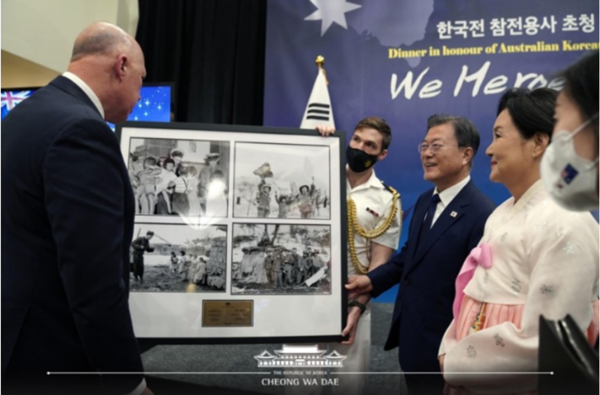 문재인 대통령이 13일(현지시간) 호주 캔버라 시내 한 호텔에서 열린 ‘한국전 참전용사 초청 만찬’ 행사장에 전시된 6.25 한국전쟁 당시 기록 사진들을 참전용사와 함께 관람하고 있다. (사진=청와대 제공)