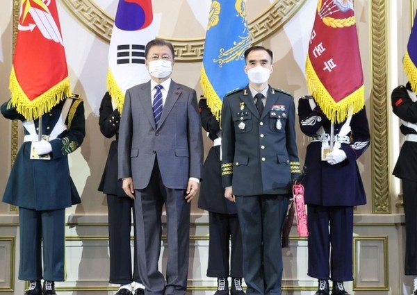 문재인 대통령이 20일 청와대 영빈관에서 열린 장성 진급 및 보직 신고를 받고 이규준 육군 제5군단장의 삼정검에 수치를 달아준 뒤 기념촬영을 하고 있다.(사진=청와대 제공)