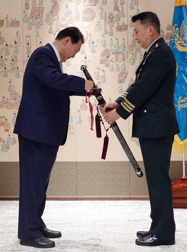윤석열 대통령이 5일 서울 용산 대통령실 청사에서 김승겸 신임 합참의장의 삼정검에 수치를 달아주고 있다.(사진=대통령실사진기자단)