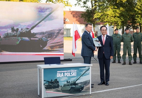 마리우스 브와슈착 폴란드 부총리 겸 국방부 장관(앞줄 왼쪽)과 이용배 현대로템 사장이 지난 27일(한국시간) 폴란드 모롱크에 있는 기계화부대에서 열린 폴란드 군비청과 K2 전차, K9 자주포 수출 1차 이행계약 체결 행사에 참석하고 있다.(사진=방위사업청 제공)