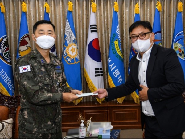 광산구소상공인연합회 김범주 회장이 27일 류진산 공군 제1전투비행단장에게 위문금을 전달하고 있다.