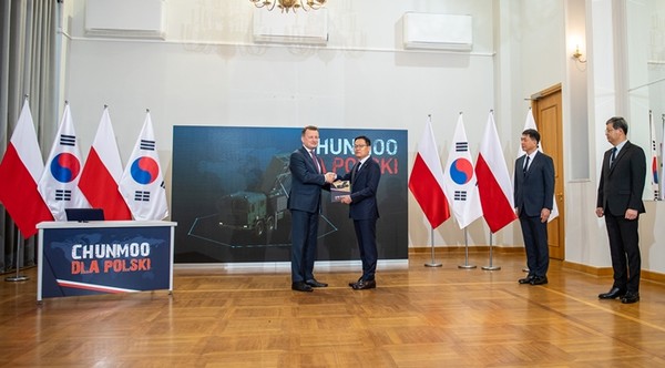 마리우시 브와쉬착 폴란드 부총리 겸 국방부장관 (왼쪽)과 한화디펜스 손재일 대표이사가 지난 19일 폴란드 바르샤바에서 열린 ‘천무’ 다연장로켓 발사대 288대와 유도탄 수출을 위한 기본 계약식에서 악수하고 있다.{사진=폴란드 국방부 제공 연합뉴스)