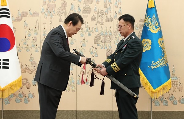 윤석열 대통령이 7일 서울 용산 대통령실 청사에서 열린 각군 중장 18명 보직 신고 및 삼정검 수치 수여식에서 강호필 육군 1군단장 삼정검에 새 수치를 달아주고 있다.(사진=대통령실통신사진기자단 연합뉴스)