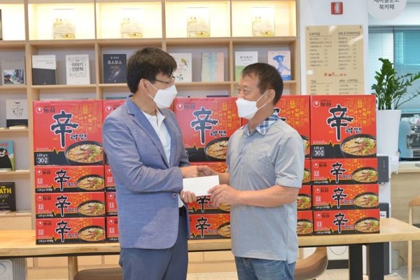 서정학 봉사단체 사계절 단장(오른쪽)이 2021년 8월 서울 중랑구 상봉2동 주민들에게 성금 100만원과 라면 50상자를 전달하고 있다. (사진=봉사단체 사계절 제공)