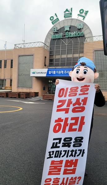 피노파밀리아 측이 국민의힘 이용호 국회의원의 지역구인 전북 임실역 앞에서 이용호 국회의원의 권력남용을 비판하는 1인 피켓시위를 하고 있다. (사진=피노파밀리아 제공)