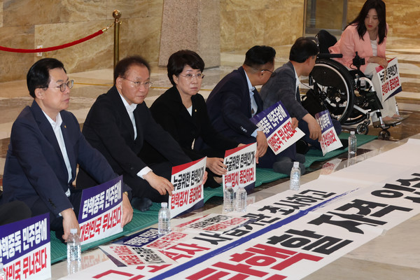 국민의힘 의원들이 3일 오후 ‘채상병특검법’에 대한 무제한 토론(필리버스터)이 진행되고 있는 국회 본회의장 앞에서 더불어민주당을 규탄하는 연좌농성을 하고 있다. (사진=연합뉴스 제공)