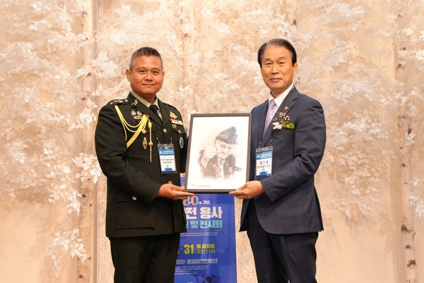 권오을 국가보훈부 장관이 30일 서울 용산구 로얄파크컨벤션에서 국방신문 주최로 열린 ‘6·25 유엔 참전용사 초상화 헌정 및 전시회’ 개막식에서 주한태국대사관 국방무관인 잇 팁파야짠 대령에게 태국 국적 참전용사의 초상화를 증정한 뒤 기념사진을 찍고 있다.