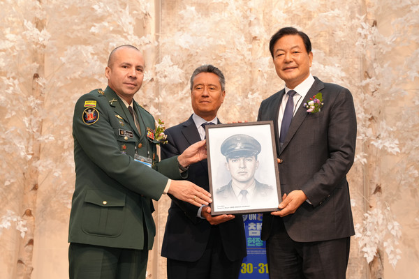 황기철 전 국가보훈처장이 30일 서울 용산구 로얄파크컨벤션에서 국방신문 주최로 열린 ‘6·25 유엔 참전용사 초상화 헌정 및 전시회’ 개막식에서 주한콜롬비아대사관 프란시스코 알베르토 곤잘레스 전권공사에게 콜롬비아 국적 참전용사의 초상화를 증정하고 기념사진을 찍고 있다.