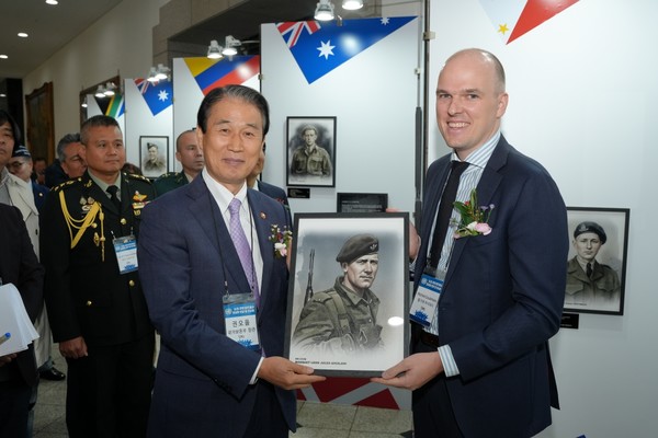 권오을 국가보훈부 장관이 30일 서울 용산구 전쟁기념관에서 국방신문 주최로 열린 ‘6·25 유엔 참전용사 초상화 헌정 및 전시회’에서 주한벨기에대사관 미킬 클레만스 공관차석에게 벨기에 국적 참전용사의 초상화를 증정하고 있다.